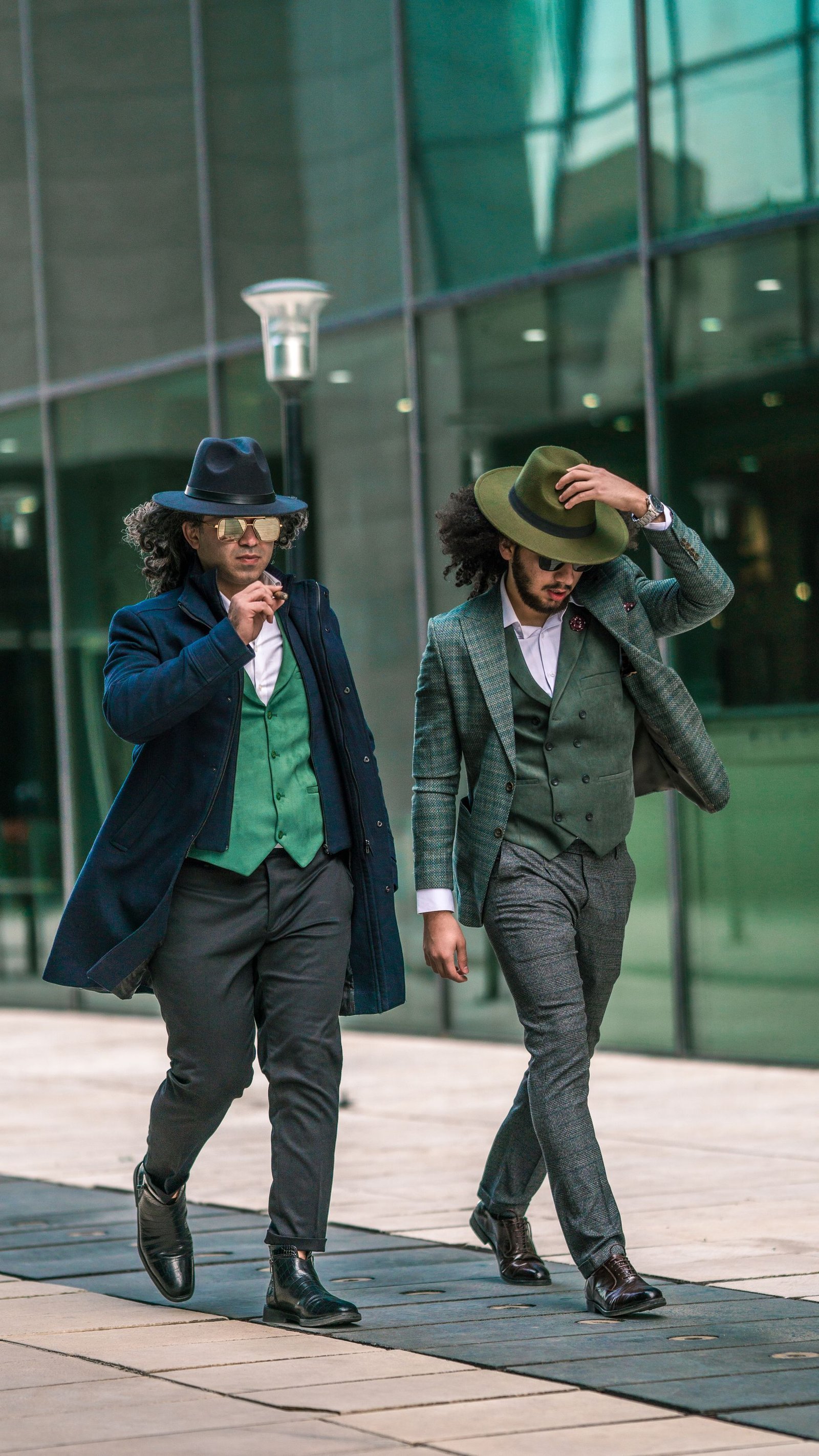 Two men walking in tailored suits and hats